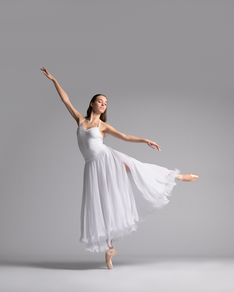 Gracefully beautify classical ballet photography all in white against a light grey background.