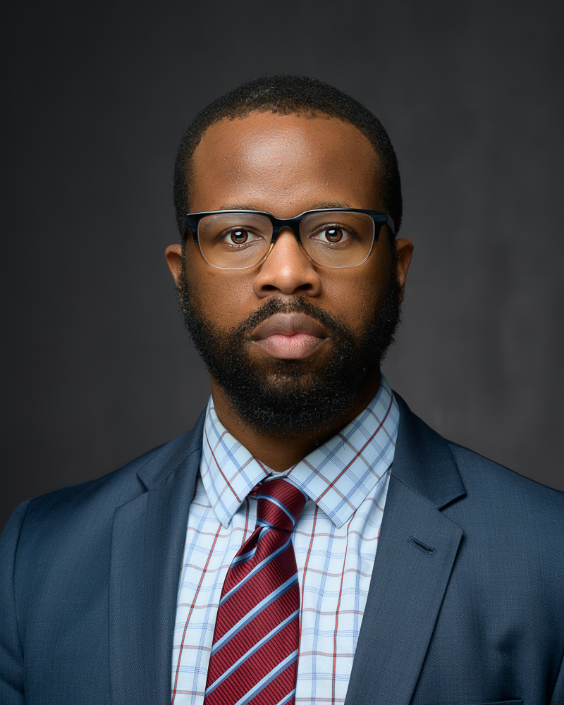 Professional Headshot of a black man wearing a suit and tie, looking confident and ready for success.