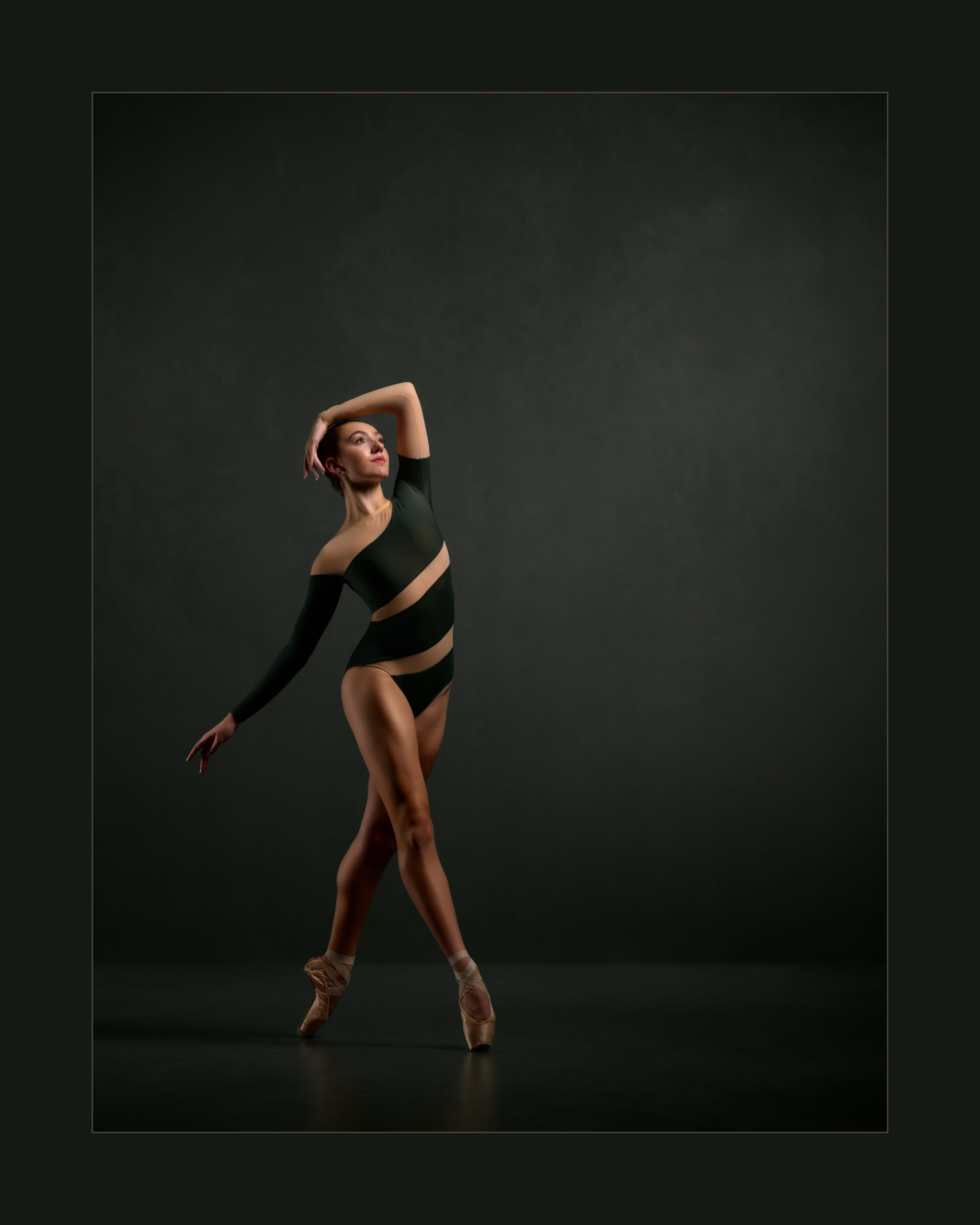 ballerina 'walking' with arm draped over her head a looking slightly upward.