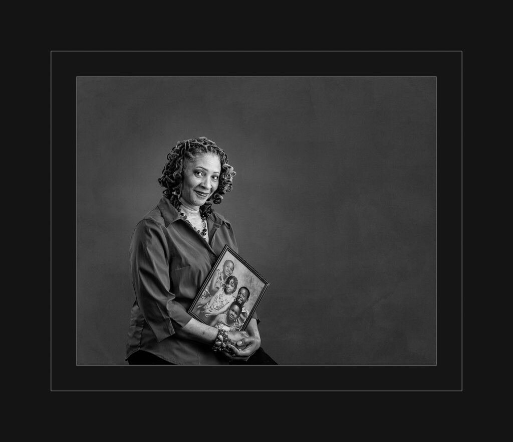 Woman holding a photo of her grandchildren.